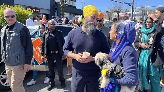 Jagmeet Singh discute avec une dame au milieu d'une foule.