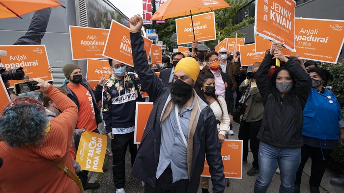 Jagmeet Singh lève le poing en l'air, entouré de partisans.