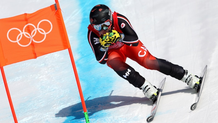 James Crawford contourne un drapeau des Jeux olympiques en piste.