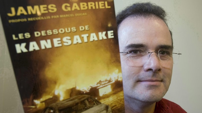  James Gabriel, l'ancien chef des Mohawks de Kanesatake, brandit un exemplaire de son livre Les dessous de Kanesatake. 