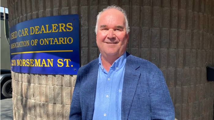 Customs prices force: buy car now or later? star-news.press/wp James Hamilton is located in front of a brick wall with a plate that represents the name of the association that directs.