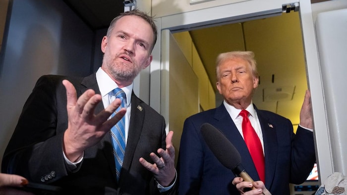 Jamieson Greer répond aux questions des médias tandis que Donald Trump se tient derrière lui. 
