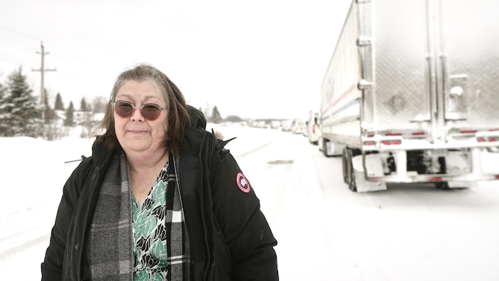 Une femme prise derrière une record de camions.