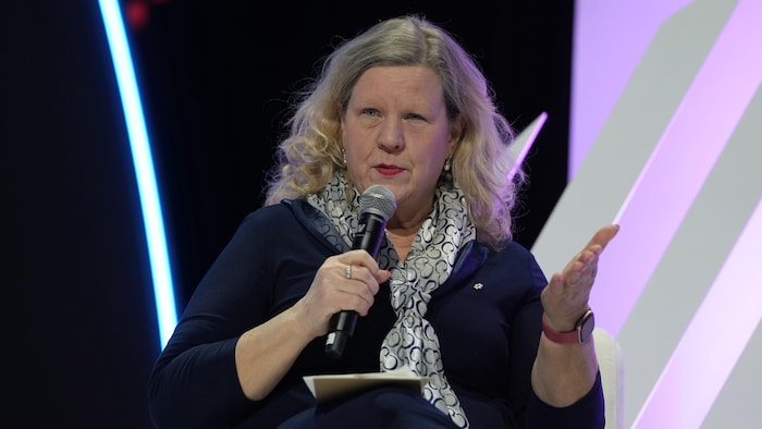 Janice Charette parle dans un micro. 