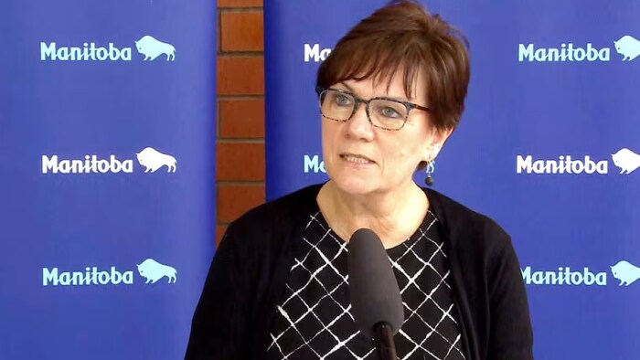 La ministre Janice Morley-Lecomte en conférence de presse devant des panneaux bleus sur lesquels le mot Manitoba est inscrit, le 2 juin 2023. 