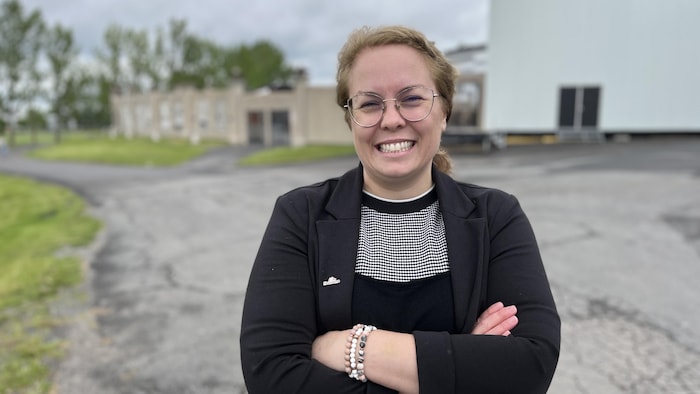 Janie Maltais sourit à la caméra les bras croisés.