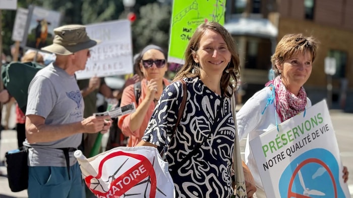 Une dame marche avec une affiche à la main. 