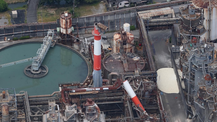 Vue aérienne d'une usine, dont une cheminée s'est effondrée.