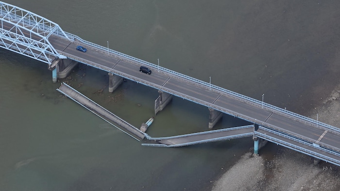 Vue aérienne de voitures qui circulent sur un pont dont une partie s'est effondrée dans l'eau.
