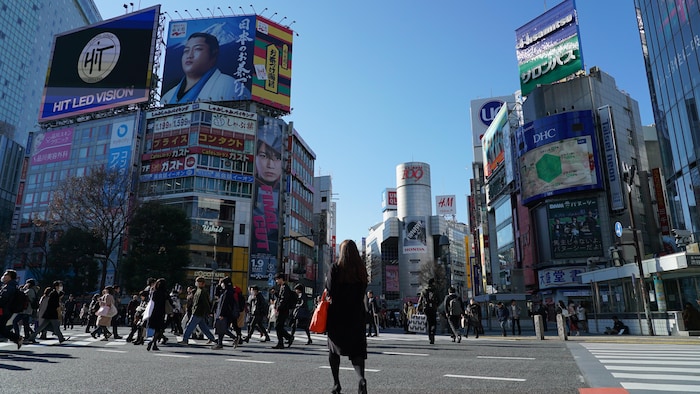 Une femme traverse le célèbre carrefour de Shibuya à Tokyo.