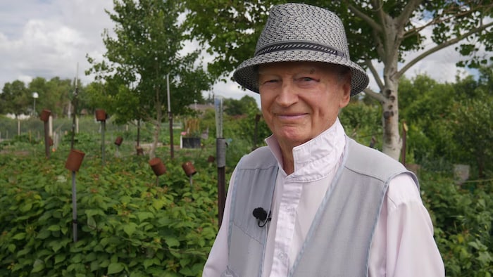 Dennis Lawrysyn se tient devant le jardin communautaire.