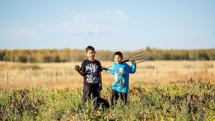 Deux enfants venus prêter main-forte dans le jardin communautaire.