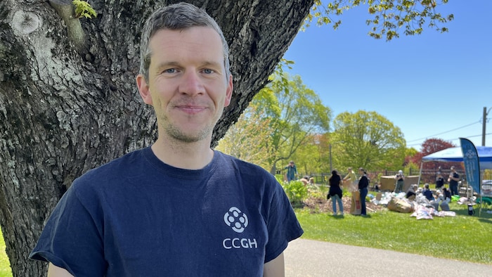 Un homme en portrait devant un jardin communautaire.