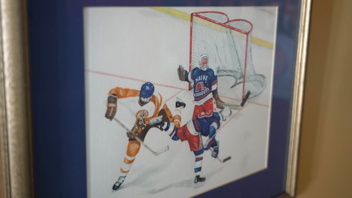 Une peinture où l'on voit deux joueurs de hockey et un gardien de but.
