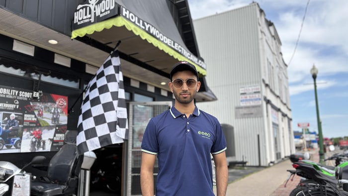Jaskirat Singh est debout devant un magasin de vélos.