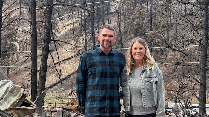 Un couple se tient devant les ruines de sa maison à Faulder, près de Summerland.
