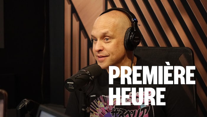 Jason Rockman le porte-parole du Comiccon de Québec assit dans un studio avec le logo de l'émission Première heure.