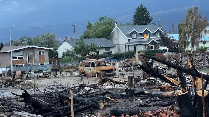 Les ruines de plusieurs maisons et une camionnette dans une rue de Jasper.