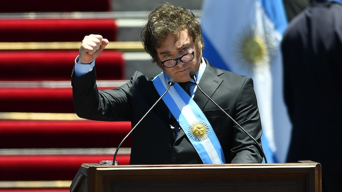 Javier Milei lève le poing lors d'un discours.