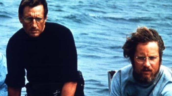 Les deux personnages sont concentrés, en bid de piloter un bateau sur l'eau.