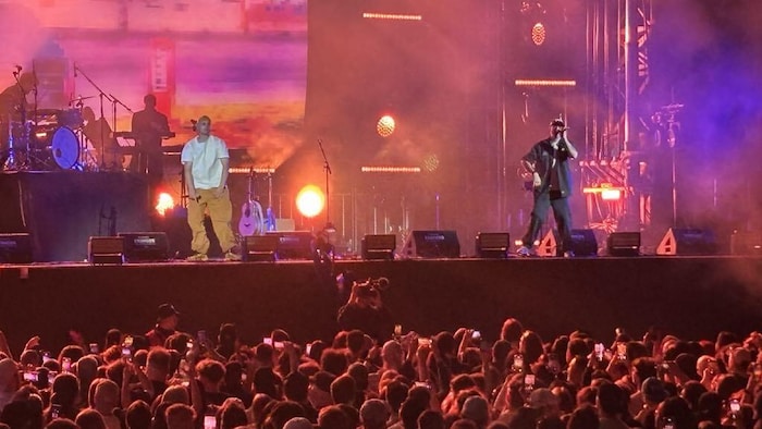 Deux rappeurs sur scène devant une foule.