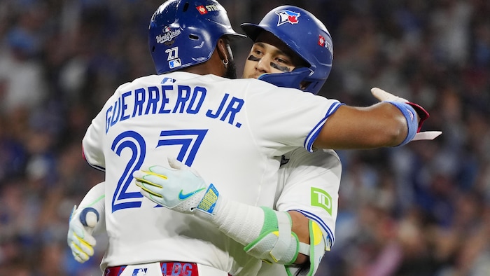 Vladimir Guerrero fils serre Bo Bichette dans ses bras sur le terrain. 