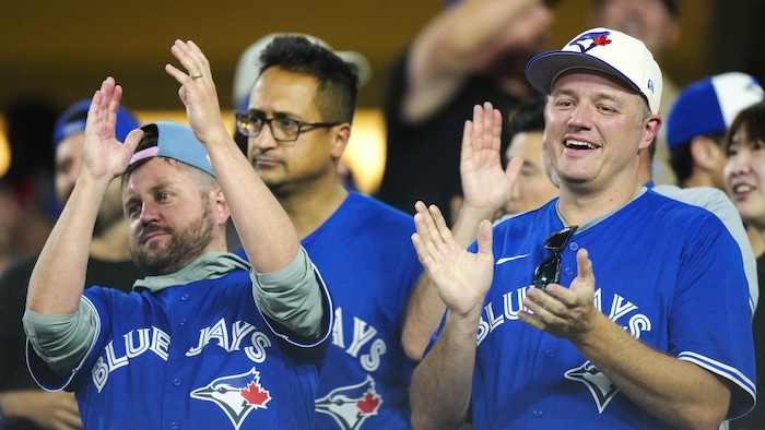 Des partisans des Blue Jays dans les gradins applaudissent.
