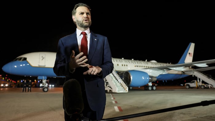 Le vice-président américain J.D. Vance s'adresse aux médias sur le tarmac d'un aéroport, la nuit.