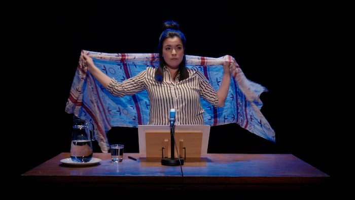 Natasha Kanapé Fontaine, sur scène, derrière un pupitre.