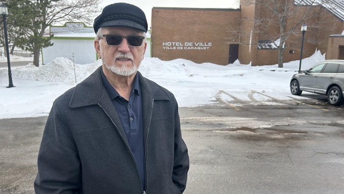 Jean-Claude Doiron sourit à l'objectif, devant l'hôtel de ville.