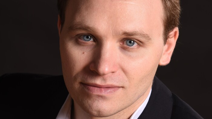 L'homme regarde l'objectif. 