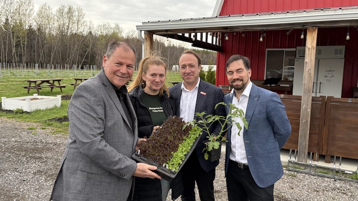 Jean-François Aubin tient des laitues avec des producteurs agricoles.