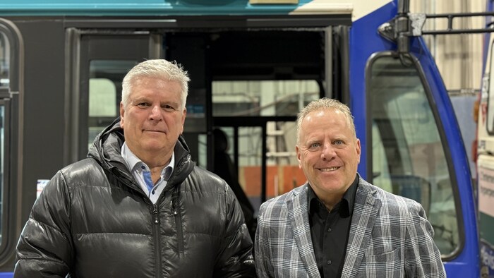 Jean-François Carrier et Jean Leblond, côte-à-côte devant un autobus de la STLévis.