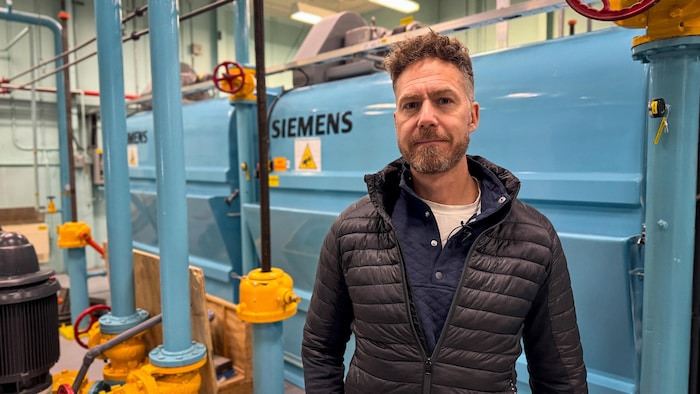 Jean-François Grenier devant des machines de traitement d'eau.