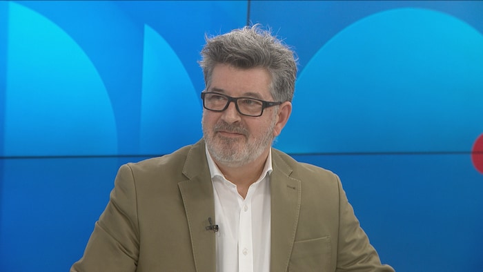 Un homme sur le plateau de Radio-Canada Acadie.