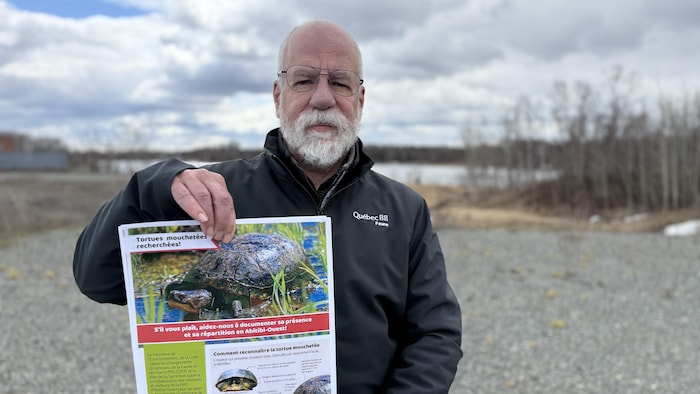 Jean Lapointe montre une affiche décrivant la tortue mouchetée.