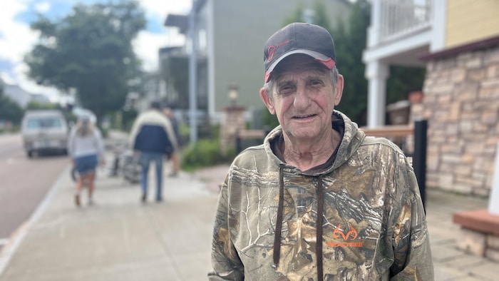 Un homme debout sur un trottoir de La Baie.