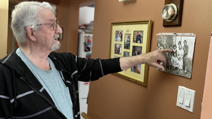 Jean-Louis Mainville pointe sa femme sur une photo de famille.