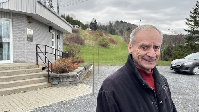 Un homme souriant devant un bureau municipal