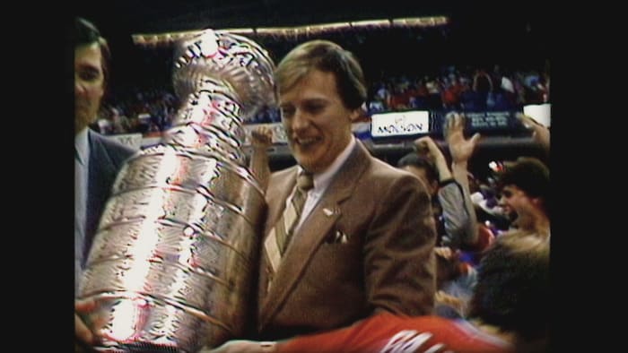 Il tient la coupe Stanley, tout souriant.