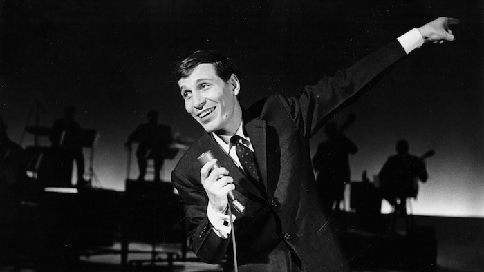 Jean-Pierre Ferland qui chante un micro à la main.