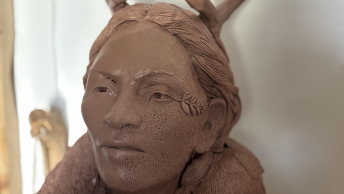 Gros plan sur un buste en argile représentant une femme-caribou.