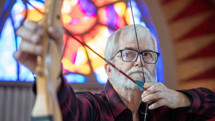 Un homme avec un arc et une flèche se prépare à tirer. 