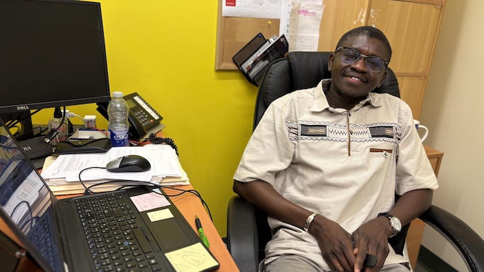 Jean-Pierre Ndiamy assis a son bureau.