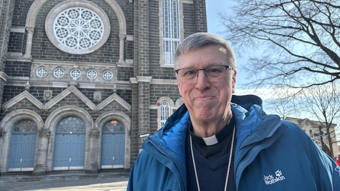 Jean Tailleur souriant à l'extérieur.