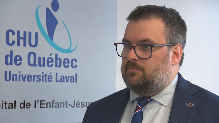 Un homme regarde la caméra.