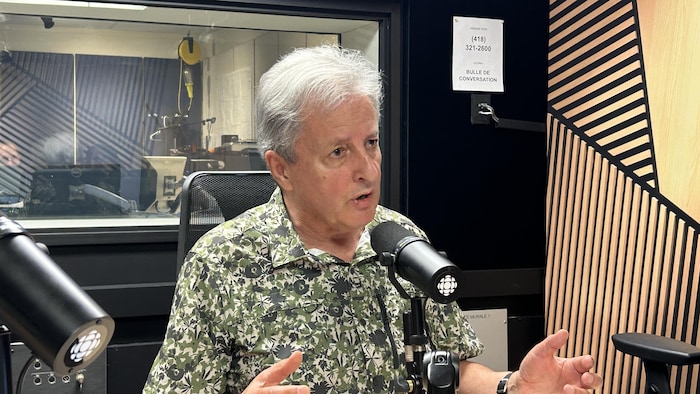 Un homme en entrevue dans un studio de radio.