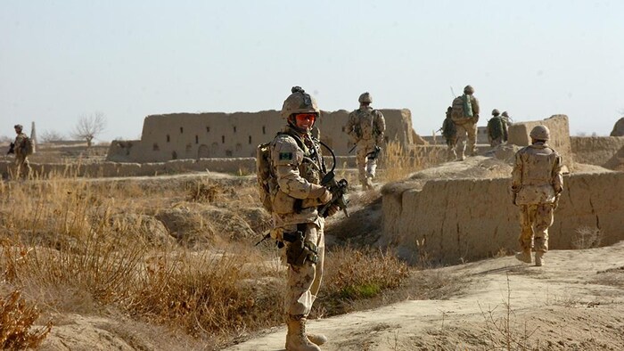 Jennie Carignan en uniforme militaire dans une zone désertique, en Afghanistan.