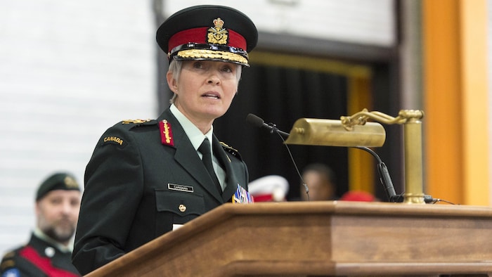 La générale Jennie Carignan prononce un discours sur une tribune lors d'une cérémonie militaire.