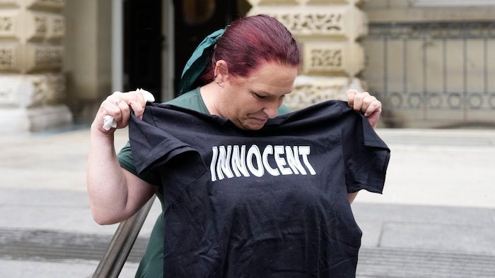 Jennifer Gaskin brandit un t-shirt offert par un sympathisant de l'Innocence Project, devant la Cour d'appel de Toronto, le mardi 29 septembre 2026. 
